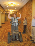 A conference attendee stands in a wheelchair after sitting in one for twenty years.
