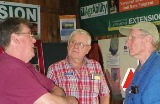 Tom Younkman (center) visits with an agricultural insurance representative and a farmer.