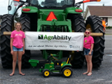 The Maine AgrAbility Project banner was proudly displayed on the John Deere tractor in the Potato Blossom Festival.