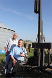 Del Ficke, Rural Rehab Specialist, and Clayton Hergott, AgrAbility client, try the portable lift for use with temporary disabilities, purchased through grants from DuPont Pioneer and Century 21.