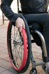 Person in wheelchair using fit grips on hand rims