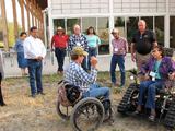 Corey McGregor teaching the TrackChair to Collena Caplett. In the back are Georgie Ann Bad Bear, Sharone Curly, JR Goes Ahead, Dr. Davis, Annie Leider, Mr. Big Man, and Bill Begley