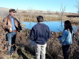 Jason Schoch (L) and Patricia Hammond (R) talking with Paul Jones at a beaver dam on SD AgrAbility's Feather 2 site