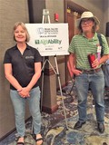 Karen Funkenbusch and Chris Allen by AgrAbility sign