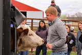 NE farmer with cow in stockade