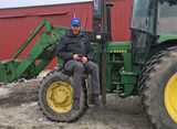 Mike Lewis sitting on tractor lift on farm