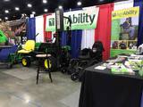 AgrAbility display at national farm machinery show showing accessible tractor, banners, and materials
