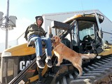 AgrAbility client with dog on tractor lift