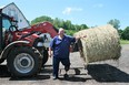 WI AgrAbility client with tractor and round  bale