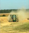 Tractor with dust rolling up behind it