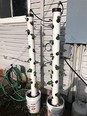 Two PVC pipes with holes in it filled with strawberry plants