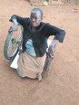 Picture of African woman Agnes sitting on her new BiCrawler on a dirt yard