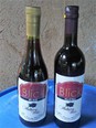 Picture of 2 bottles of Blick Mulberry Wine sitting on a blue tray that is resting on gray cement 