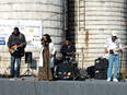 DieDra, the "Alabama Blues Queen" and the Ruff Pro Band playing on a semi truck flatbed trailor in front of two silos on the Boyd farm