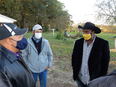 John Jamerson, Ed Sheldon, and Dr. John Boyd  with facemasks on talking together outside on Boyd's farm