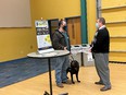 Two gentlemen facing each other with face masks on - the one on the left having a black lab service dog at the AgrAbility-FVC workshop at Purdue University