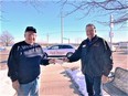 Pic of Tim Sullivan from Farm Rescue on Rt handing a $1000 check to Rod Peterson of NE AgrAbility outside on a sunny cold day.