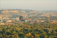 Skyline of Billings Montana with fall-colored trees in foreground the city in the center and sand-colored bluffs in the background