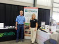 Chuck Baldwin left & Dee Jepsen rt standing on each side of Ohio AgrAbility banner and between NAP and Ohio AgrAbility display tables backed by black curtain