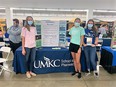 3 female students from UMKS School of Pharmacy in front of booth at MO State Fair