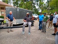Bill Begley in blue polo shirt on left demonstrating truck lift to group of Black men on right