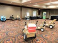 7 mobility carts-wheelchairs in a conference room with display tables draped in black in background