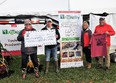 Man and woman on left holding very large check to OH AgrAbility for $2600 and OH AgrAbility banner in center with Dee Jepsen and a man on right