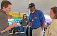 Inside tent with white man on left speaking to black man and white woman with another white woman in the background listening