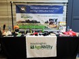 Display table with cloth reading WASHINGTON AGRABILITY - many items on table and banner in background reading ARE INJURIES OR HEALTH CONDITIONS MAKING IT DIFFICULT TO FARM