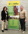 Indiana AgrAbility stand-up banner with a woman in black jackeet and cream pants on left & man in cream jackete & black pants on right. 