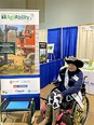 2022 North Carolina Miss Agriculture Advocacy Ambassador Katie Haynes in wheelchair in front of NC AgrAbility banner