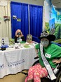 2022 North Carolina Miss Agriculture Advocacy Ambassador Katie Haynes in wheelchair in front of NCA&T booth