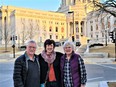 Man on left & 2 women standing in front of Madison WI capitol building.