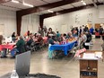 People eating at long tables in a large metal building at Cheyenne County Health Fair