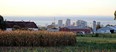 Skyline of Columbus Ohio with corn field in foreground - farm buildings in center - Columbus in background