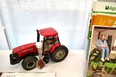 Small table-top model of a Case tractor with a chair lift on it sitting next to some AgrAbility brochures