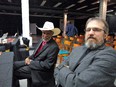 Seated African American farmer in dark suit with red shirt & bolo tie & white Stetson next to Ed Sheldon in gray suit at NBFA conference