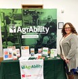 Woman - Emily Jacobson - on right next to Nebraska AgrAbility banner and table with printed materials