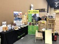 Black-draped AgrAbility table on left with printed materials - AgrAbility banner in center - bee care display on right