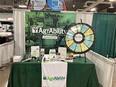 Green-draped table with spinning game wheel and NE AgrAbility literature on it with NE AgrAbility banner behind it