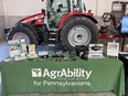 AgrAbility for Pennsylvanians display table with Massey Ferguson tractor behind it
