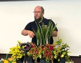 Derrick Stowell leading a class with houseplants and some AT gardening tools on a table in front of him
