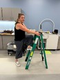 Woman in a room climbing a green step ladder