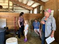 Deb talking to farm group inside a farm building about assessing farm structures.