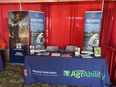 IL AgrAbility booth with a table - three stand-up banners - and red drapes in the background
