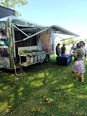 People looking at plant displays under the awning of a trailer