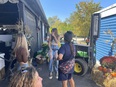 A young woman trying out the tractor lift while 3 other women watch at the Farm Aid concert