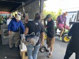 Bill Field at the Farm Aid concert AgrAbility booth with several people looking on and a young man on the right trying the tractor lift