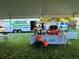 TN AgrAbility table and assistive technology under a tent with a rescue & response truck & trailer behind it