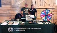 Kirsten Wulfsberg & Jen Aengst standing behind CO AgrAbility display table